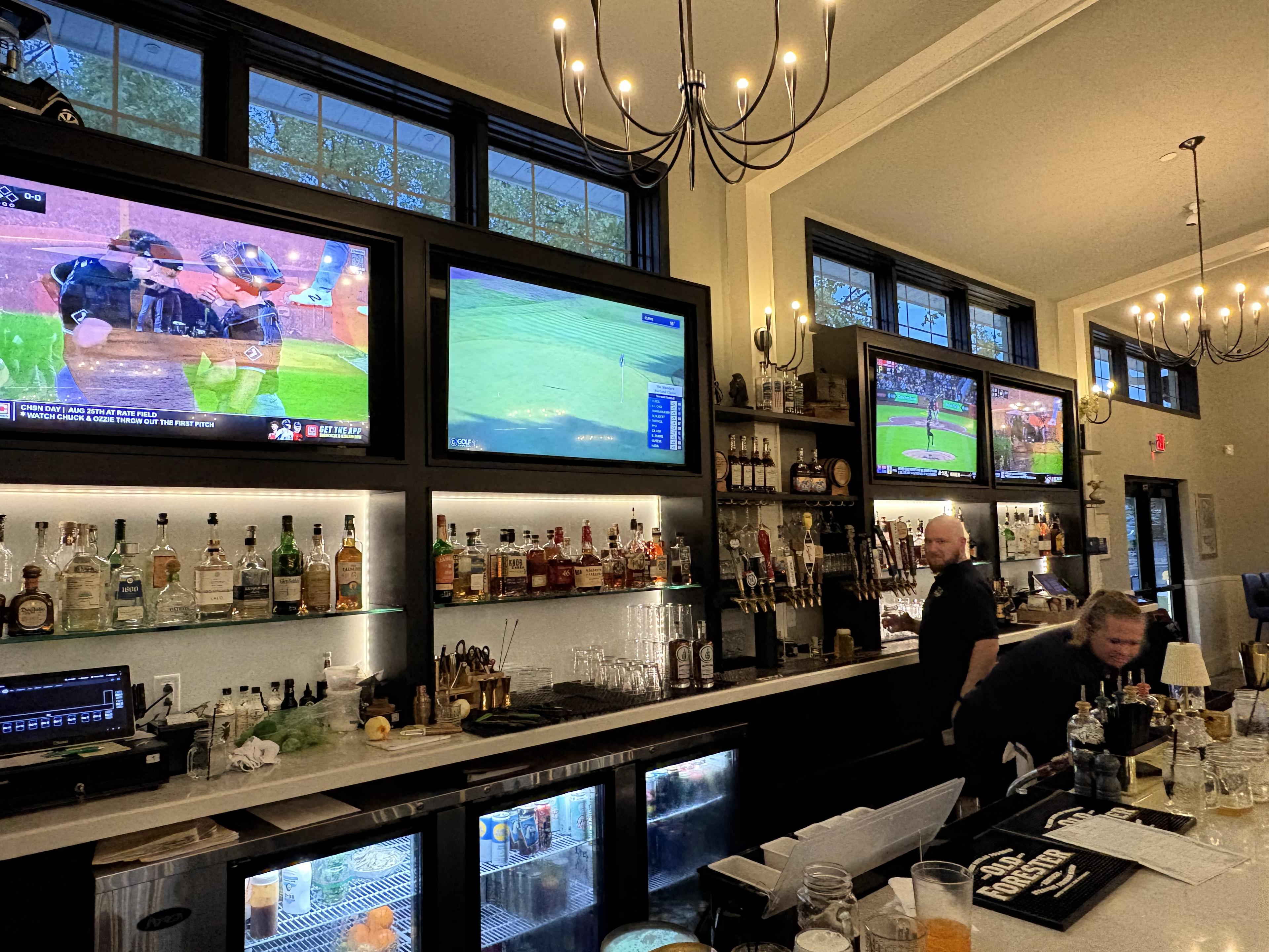Screens at the Fairways at GLC bar showing sports